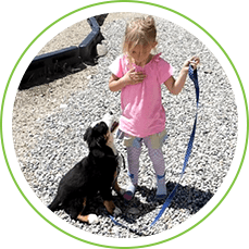 A girl holding onto the leash of her dog